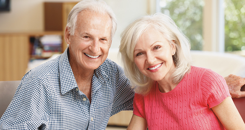 Older couple with dental implants smiles
